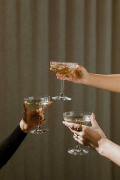 four people holding wine glasses in their hands