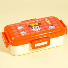 an orange and white lunch box with mickey mouse on it