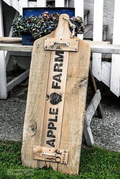 a wooden sign sitting on top of a grass covered field