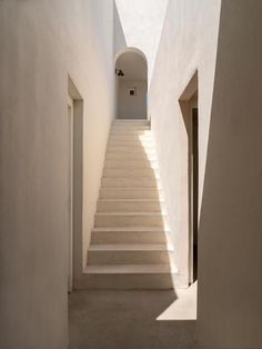 an empty hallway with white walls and stairs