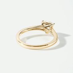 a yellow gold ring with a diamond in the center and an arrow at the top