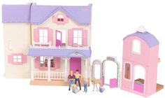 a doll house with two people and a dog in front of it, next to a toy horse stable