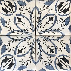 the blue and white tiles are decorated with black leaves, vines and swirls on them