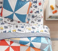 a child's bed with construction themed sheets and pillows