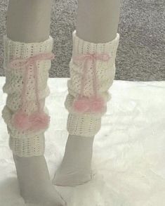 there is a woman's legs with crocheted socks and pink bows on them