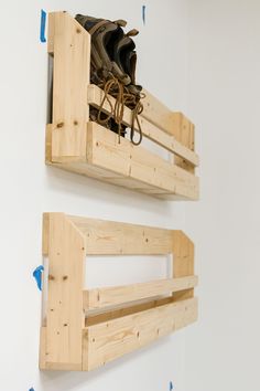 two wooden shelves with shoes on them hanging from the wall next to another pair of shoes