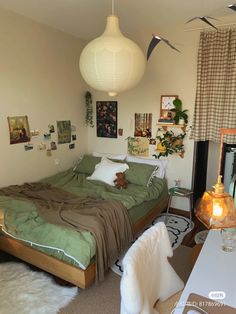 a bed room with a neatly made bed next to a table and lamps hanging from the ceiling