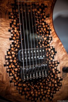 an electric guitar is made out of wood and has intricate designs on the top part of it