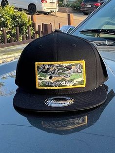 embroidered camo patch on a snapback flatbill black hat with gold merrow. Black Snapback Hat With Patches, Camouflage Snapback Hat For Streetwear, Snapback Hat With Embroidered Patch, Snapback Hats With Patches For Streetwear, Streetwear Snapback Hat With Patches, Black Snapback Hat With Embroidered Patch, Black Snapback Hat With Embroidered Patch For Outdoor, Outdoor Black Snapback Hat With Embroidered Patch, Streetwear Snapback Hat With Embroidered Patch