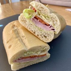 a cut in half sandwich sitting on top of a blue plate next to a baguette