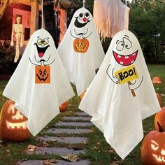 halloween decorations with ghost faces and pumpkins in front of a house decorated for halloween