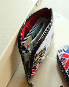 two zippered wallets sitting next to each other on top of a white table