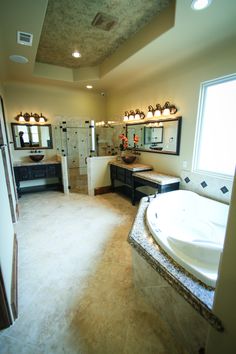 a large bathroom with two sinks and a bathtub in the middle of the room