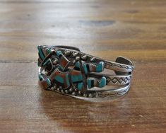 "Stunning vintage Zuni sterling silver cuff bracelet with a beautifully inlaid multi-stone Rainbow Yei in the center and stamped designs on either side. The components used in the inlay are turquoise, coral, mother of pearl, and jet. The bracelet measures 5 1/2\" on the inside, plus a 1\" gap. It is 1 1/8\" wide, at the widest point. The piece is signed \"ME OA\" on the inside and guaranteed to be sterling silver. Gorgeous and collectible vintage bracelet! Feel free to ask any questions and than Artisan Silver Cuff Bracelet With Inlay, Vintage Bangle Cuff Bracelet With Inlay, Bohemian Turquoise Inlay Cuff Bracelet, Vintage Inlay Cuff Bracelet Bangle, Vintage Turquoise Cuff Bracelet, Vintage Inlay Cuff Bracelet, Vintage Turquoise Sterling Silver Cuff Bracelet, Southwestern Silver Bracelet With Multi-stone, Silver Artisan Multi-stone Cuff Bracelet