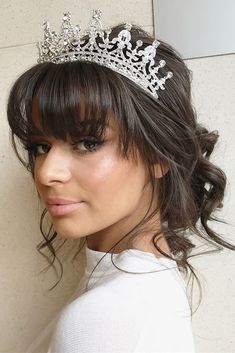 a woman wearing a tiara against a wall