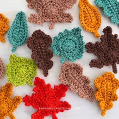 crocheted leaves are arranged on a white surface