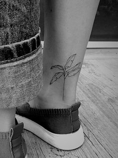 a woman's foot with a small flower tattoo on her left side calfocks