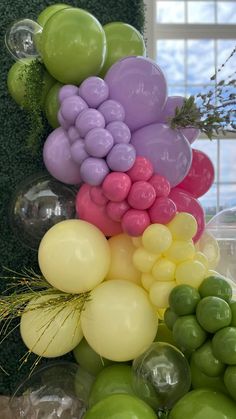 there are many balloons in the shape of a pyramid on top of some green and yellow balls