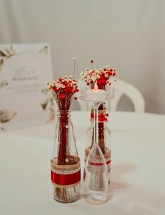 two vases with flowers in them sitting on a table