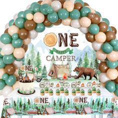 a one year camper themed birthday party with balloons and decorations, including a cake table