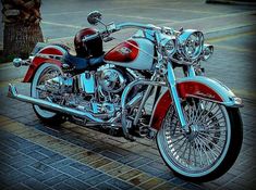 a red and white motorcycle parked next to a tree