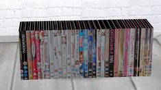 a stack of dvd's sitting on top of a wooden floor next to a brick wall