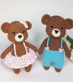 two crocheted teddy bears are posed next to each other