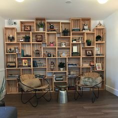 two chairs sitting in front of a book shelf filled with books