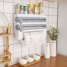 a kitchen with white tile walls and wooden counter tops, including a paper towel dispenser