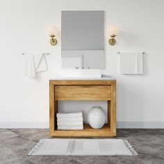 a bathroom with a sink, mirror and towels on the shelf in front of it