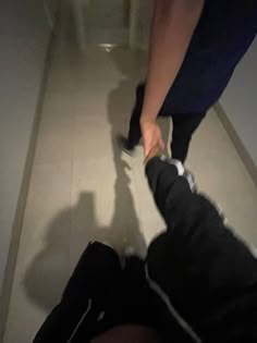 two people holding hands while standing on the floor