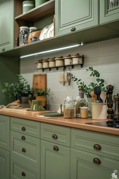 a kitchen with green cabinets and wooden counter tops