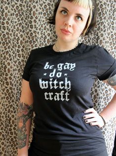 Discover your true power with this original Be Gay Do Witch Craft Tee. It's crafted of super soft cotton and adorned with enchanting words of queer pride, empowering you to be bold and embrace the witch within. Unleash the magic! Each garment is hand screen printed by yours truly! Super soft unisex black tee, made with 100% combed and ring-spun cotton. Shirts are manufactured in ethical WRAP* certified factories. Unisex sizes XS-4XL.*WRAP (Worldwide Responsible Accredited Production) is a global Cotton Slogan Tops For Alternative Fashion, Cotton Tops With Slogan For Alternative Fashion, Cotton Tops With Text Print For Alternative Fashion, Witchy Cotton Tops With Letter Print, Cotton Pride Slogan Tops, Pride Slogan Cotton Tops, Cotton Slogan Tops For Pride Festival, Cotton Slogan Tops For Pride, Cotton Screen Print Tops For Pride