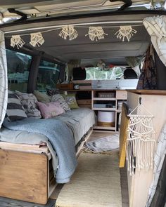 the interior of an rv with bed and storage area in it, including drawers and shelves