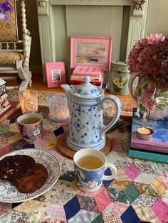 a table topped with plates and cups filled with food next to a vase full of flowers