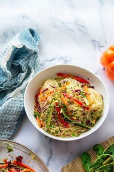 a white bowl filled with vegetables on top of a counter next to a cutting board