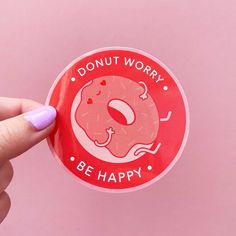 a sticker with the words donut worry be happy on it is being held by a woman's hand