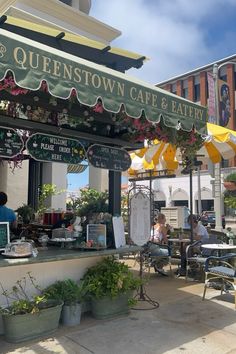 an outdoor cafe and eatery with people sitting at tables under the awnings