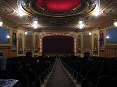 an empty theater with rows of seats facing the stage