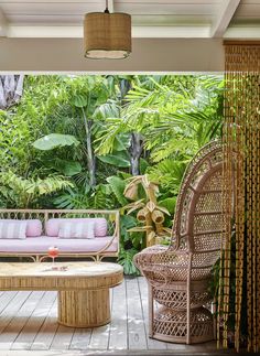 an outdoor living area with wicker furniture and plants