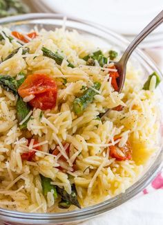 a glass bowl filled with pasta and vegetables