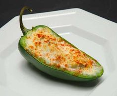 a green chili pepper sitting on top of a white plate