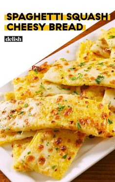 a white plate topped with cheesy bread on top of a wooden table