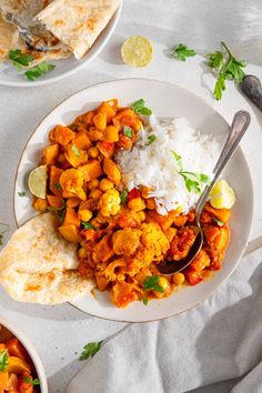 two bowls filled with curry and cauliflower next to tortillas