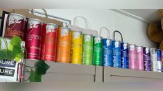 there are many colorful cans on the shelf next to a teddy bear and other items