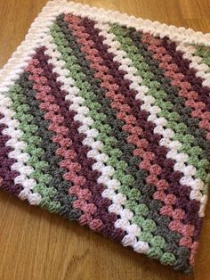 a crocheted dishcloth sitting on top of a wooden table