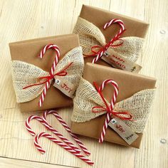 three wrapped presents with candy canes and twine