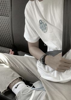 a young man sitting in the back seat of a car with his arm wrapped around an object