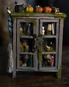 an old wooden cabinet with moss growing on it's sides and glass doors that are open