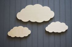 three wooden clouds hanging on the side of a building